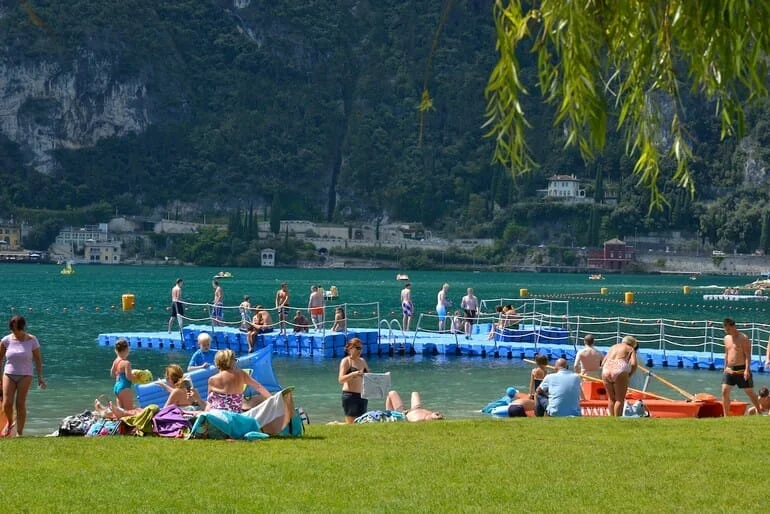 Persone rilassanti sul prato vicino al lago.