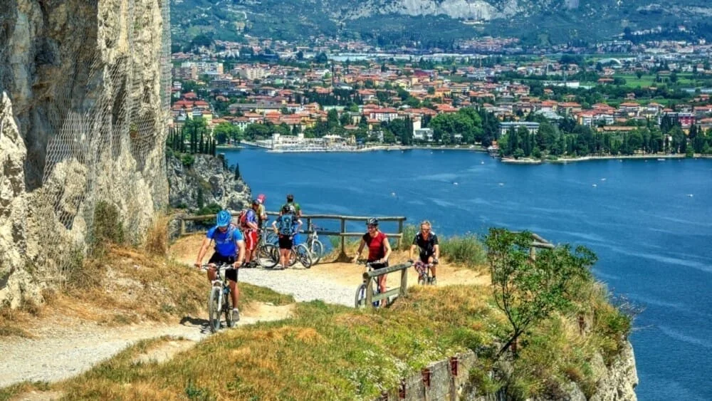 Ciclisti in montagna con vista su lago panoramico.