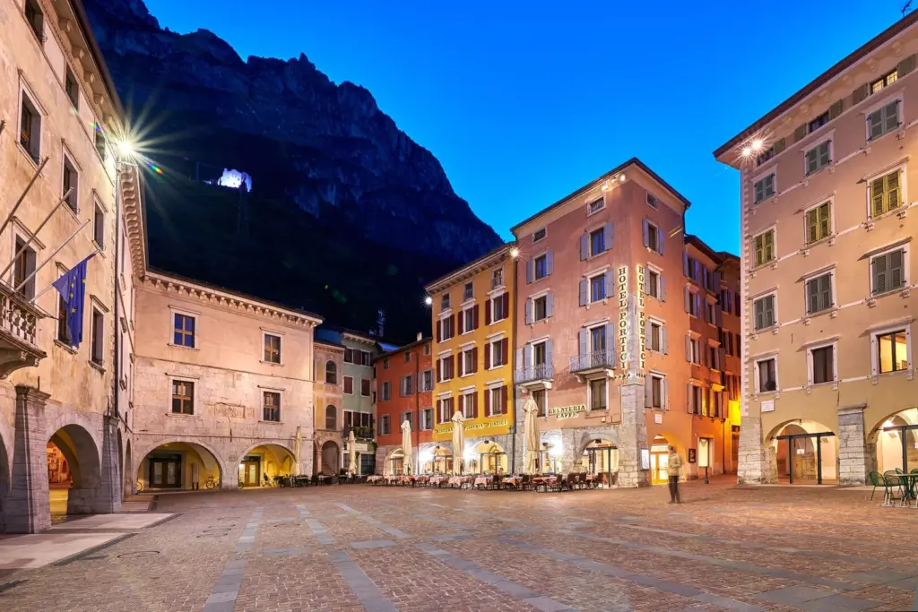 Piazza italiana con edifici colorati al tramonto.