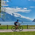 Ciclista lungo il Lago con montagne